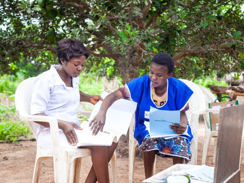 Health worker Caroline Nyior (left) comparing the patient register at the health facility where she works with Blessing Ichekula’s referral records. Photo credit: Management Sciences for Health